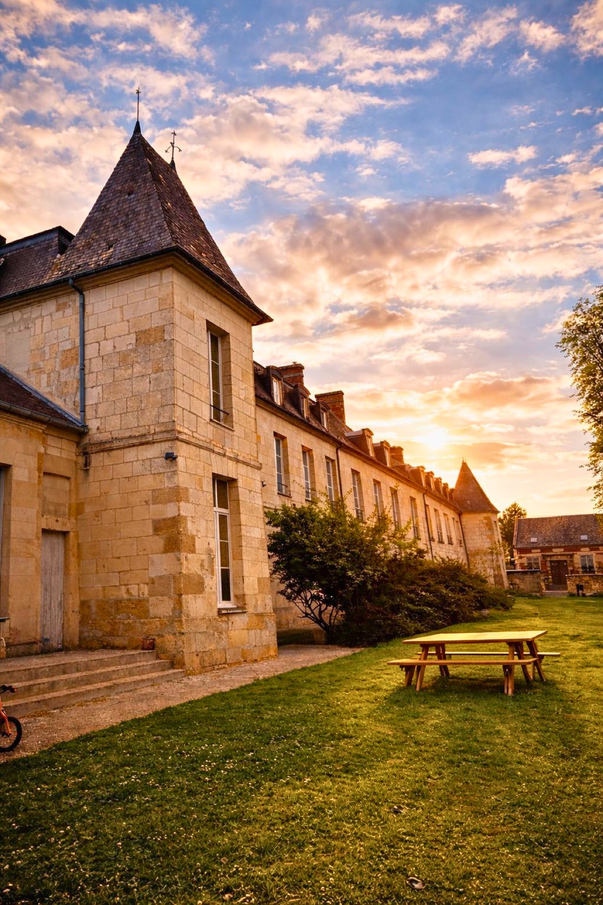 Façade du Château de Ravenel au coucher du soleil avec son parc