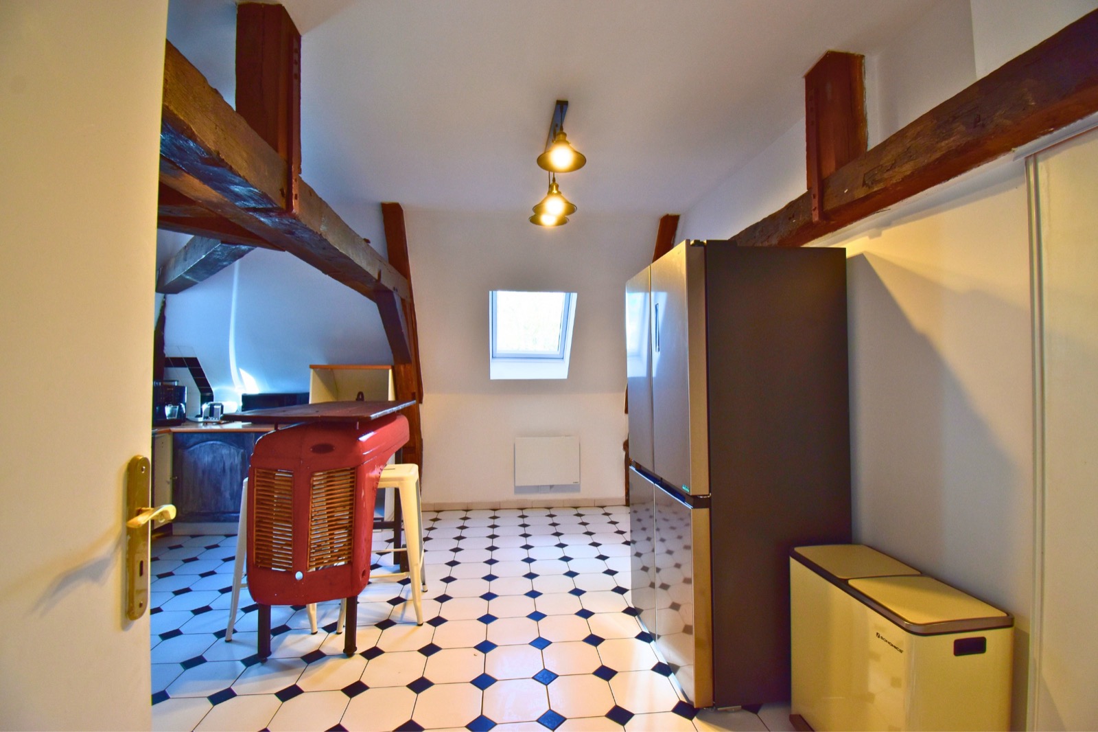 Le Loft des Charpentiers du Roi — cuisine avec poutres et carrelage damier