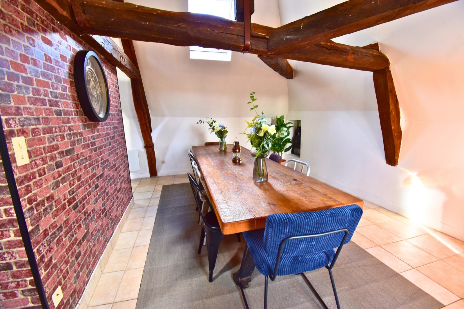 Le Loft des Charpentiers du Roi — table à manger mur en brique